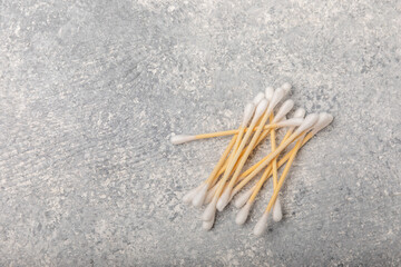 Cotton buds on a light concrete background.Eco-friendly materials. Wooden, cotton swabs on a white background.Bamboo swabs and cotton flowers.Zero waste, plastic free lifestyle concept.Place for text.