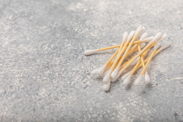 Cotton buds on a light concrete background.Eco-friendly materials. Wooden, cotton swabs on a white background.Bamboo swabs and cotton flowers.Zero waste, plastic free lifestyle concept.Place for text.