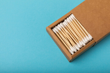 Cotton buds on a blue background.Eco-friendly materials. Wooden, cotton swabs on a white background.Bamboo swabs and cotton flowers.Zero waste, plastic free lifestyle concept.Place for text.