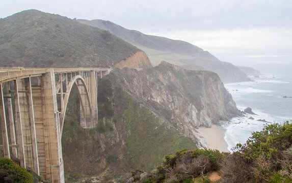 Bixby Bridge with the rocky Big Sur coastline behind in it off the Pacific Coast Highway in California.