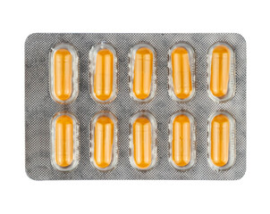 Yellow pills in a plastic blister package on transparent background