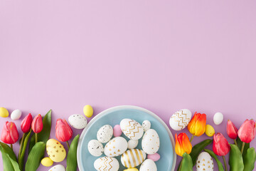 Fototapeta na wymiar Easter celebration concept. Top view composition of blue plate with colorful eggs red tulips on pastel lilac background copyspace