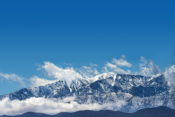 Clouds at snow capped mountain range in Southern California