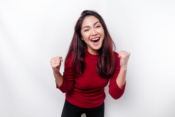 A young Asian woman with a happy successful expression wearing red top isolated by white background