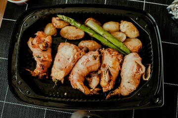 Lunch box containing prawns, asparagus and potatoes on the table