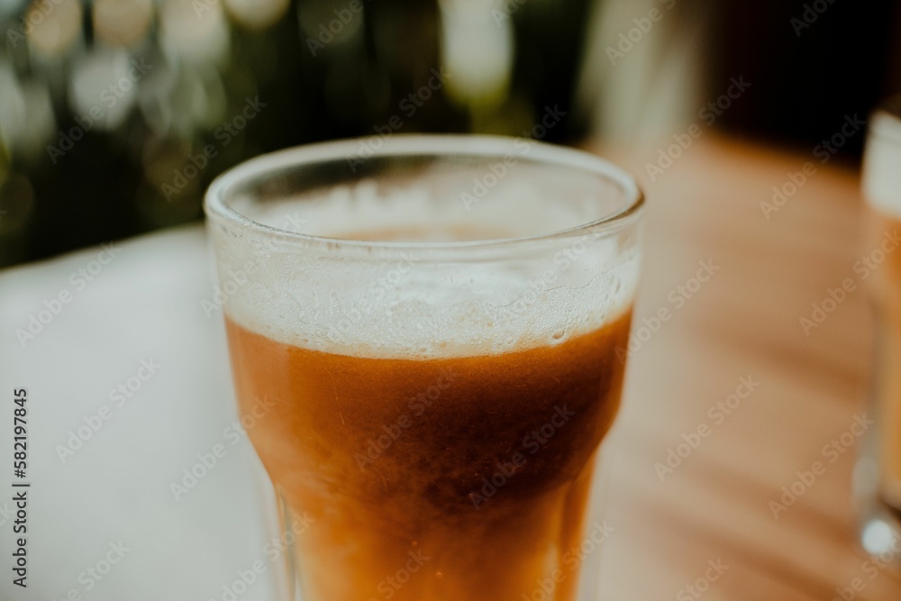 Sticker Glass of a Tamarind drink on a wooden table