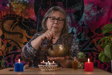 Elderly woman holding a Tibetan singing bowl in a colorful dress
