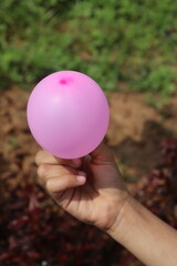 Small Pink Baloon on a Little Hand With Nature Background