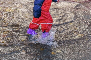 boy walking on a puddle on a rainy day