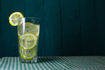 transparent glass of lemonade with fresh lemon slices on a beautiful background