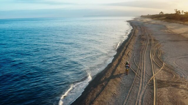 Motocross running on the beach near the ocean at sunset