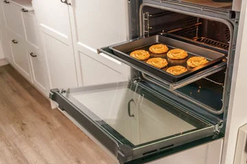 Tuinposter cookies on a tray in the oven © Jose Antona/Wirestock Creators