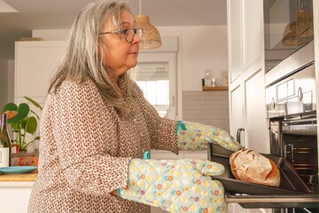 woman putting bread in the oven