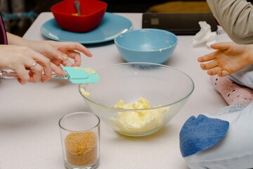 children with their mother preparing a cake