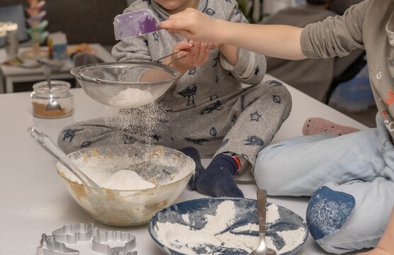 children adding flour to a cake mixture