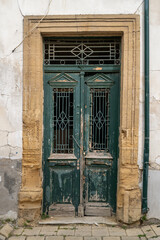 An old house entrance from 1934 with a double-winged front door made of very weathered wood.