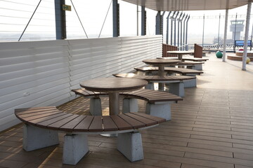 Fototapeta na wymiar 仙台空港屋上デッキ・円形の木製ベンチが並ぶ