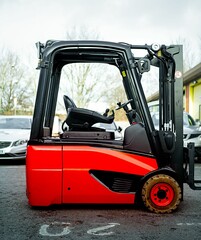 Battery powered electric Forklift truck sat in the warehouse yard red color counter balance