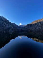 Vertical shot of a calm lake surrounded by mountains