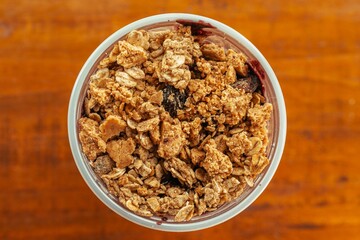 overhead photoof a creamy acai bowl with granola and banana on wooden background