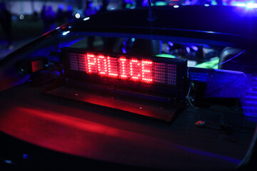 Napis police - świeci na szybie radiowozu policji.  - obrazy, fototapety, plakaty