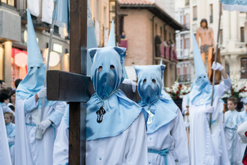 Dos cofrades portan una cruz de madera de gran tamaño durante una de las procesiones de Semana...