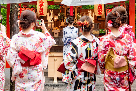 Un grupo de chicas j&oacute;venes vestidas con kimonos tomando una fotograf&iacute;a a otra amiga en un templo de la deidad Inari. Concepto de turismo en Kioto, Jap&oacute;n.