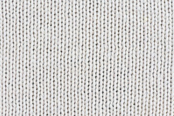 Close-up of cream-colored knit fabric for backgrounds and designs.