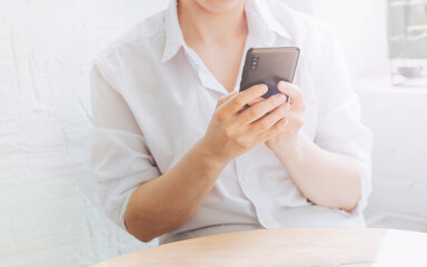 The woman writes a message on her phone and communicates on the Internet. The freelancer works online and communicates via video.