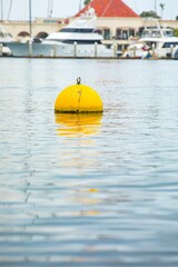 Yellow buoy in water at the port near San Diego, blurred background
