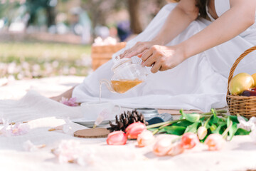 Afternoon tea in the garden, Close up hand of woman pouring tea , Relaxation and lifestyle concept.
