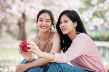 Naklejka premium Happy asian woman friends enjoying picnic in the garden, LGBT people spending time together on vacation summer.