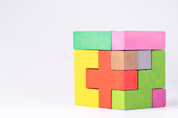 Colorful wooden cube puzzle on the white table. Concept of decision making process, logical...