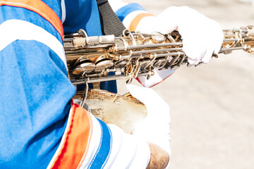 Closeup of marching band holding a saxophone.
