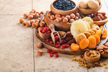 Tu Bishvat celebration concept. Mix of dry fruits and nuts almonds, hazelnuts, walnuts, apricots, prunes, cherries, raisins, dates, apples, figs over wooden table. Jewish holiday, new year of trees.