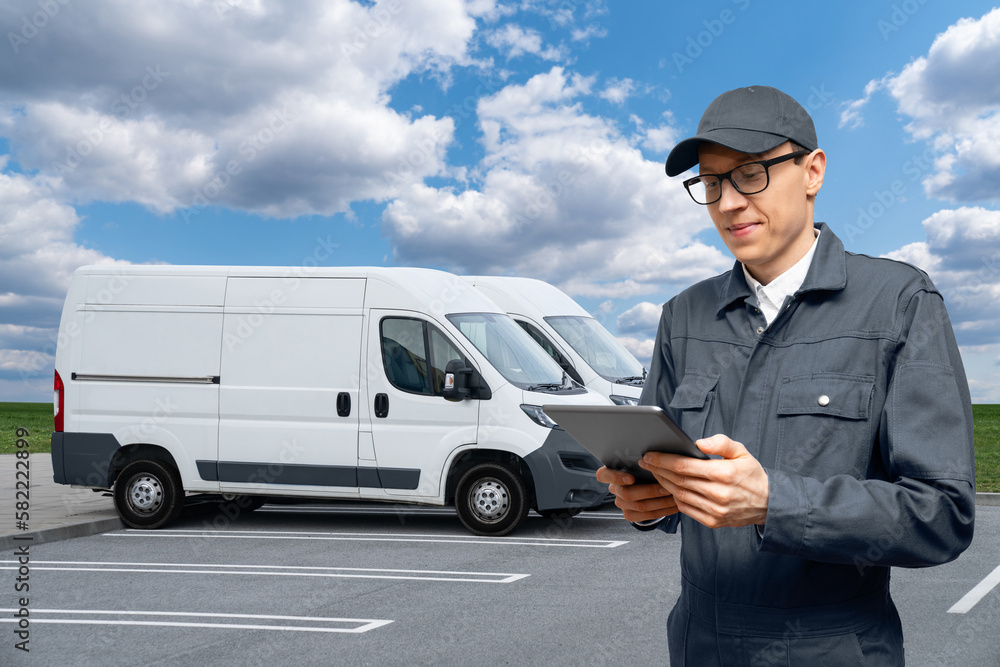 Poster Manager with a digital tablet on the background of vans. Fleet management	