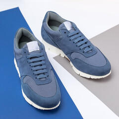 Menswear concept. Angle view photo of casual mens shoes on blue and white background