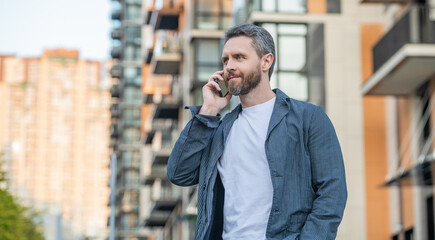 photo of positive man call on mobile phone. man has mobile call outdoor.