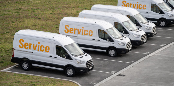 Service vans are parked in row. Commercial fleet