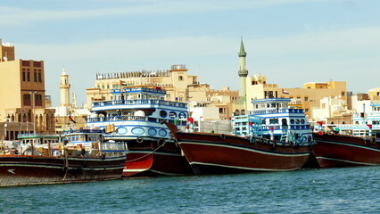 Fototapeta na wymiar malerische Schiffe auf dem Meeresarm Creek in der Altstadt von Dubai vor alten Häusern und Moschee