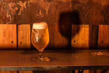 pinta vaso de cerveza artesanal contraluz, cerveceria, recarga, dorado, fondo rustico, sombra