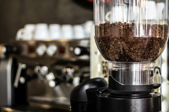 molinillo de cafe en cafeteria cafetera al fodo desenfocada, granos de caf&eacute;, cafetera, cafetera al fondo, pocillos de caf&eacute;