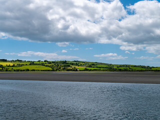 White cumulus clouds in the sky over the hilly Irish countryside. Green hills on a nice summer day....
