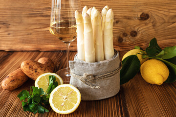 Fresh white asparagus with ingredients for a menu on rustic wood. Kitchen scene for a seasonal and...
