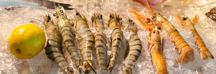 Raw and cooked shrimp on ice in a supermarket or restaurant close-up.