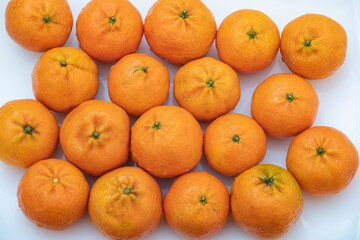 tangerine on a white background. How to choose, store and how much you can eat so as not to harm the body.	