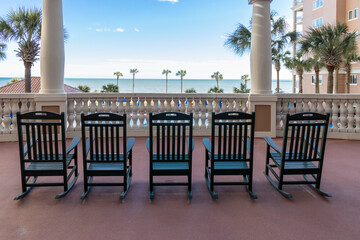 rocking chairs on the terrace overlooking ocean and blue sky
