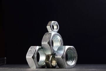 composition of nuts bolts and scraps of metal laid out on a dark background.