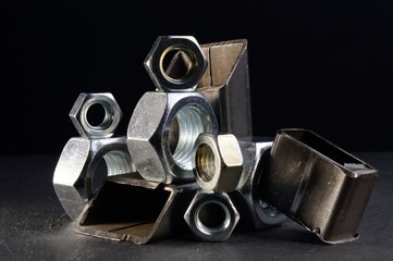 composition of nuts bolts and scraps of metal laid out on a dark background.