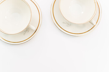 immagine con eleganti tazze da tea in porcellana con disegni oro su sfondo bianco
